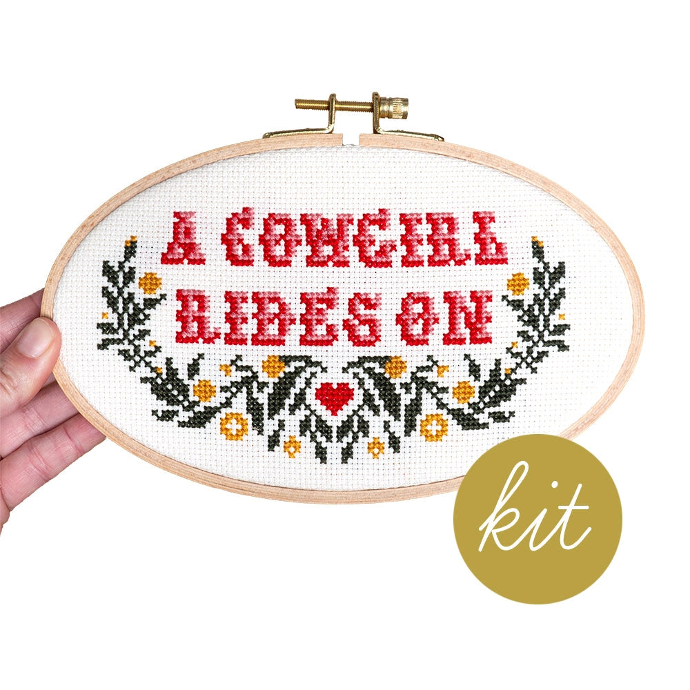 A cowgirl rides on cross stitch kit