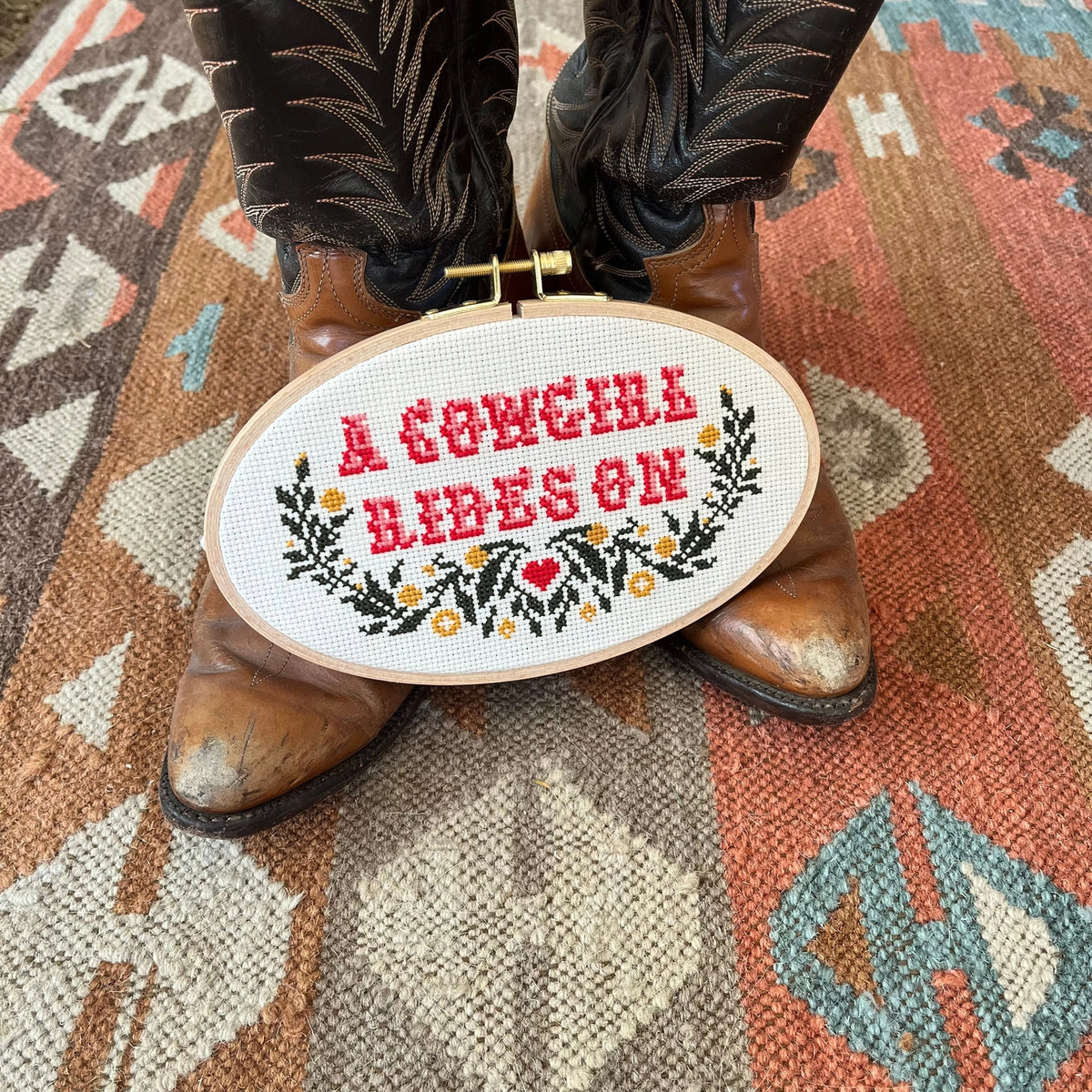 A cowgirl rides on cross stitch kit